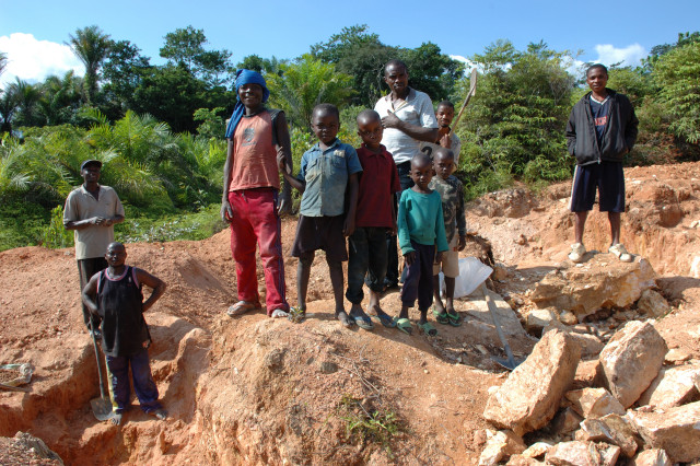 The mine was a challenge to my preconceptions. In Kailo they mine wolframite and casserite. Before the war the mines were operated by a state run company, the defunct infrastructure can be glimpsed under bushes and vines. The company still has a smart office in the centre of the village, but instead of mining they take a percentage of the proceeds of the artisan miners and the traders. Most of the workers are from the area, although I met some from the province of Kasai. Children were working with their parents, helping with panning for the ore, carrying and selling goods to the workers. The mine is made up of widely dispersed open pits. Most pits were 4 to 10 metres deep with the occasional 25 metre pit. Next to the pits were the temporary huts of the workers. There did not appear to be the squalor or disease that we find in gold mines. Although there were maison de tolerance as they are politely called here with the associated risks of sexual diseases, AIDS and child prostitution. As we left the mine we crossed two four wheel drive cars carrying men from a British company interested in investing in the mine.